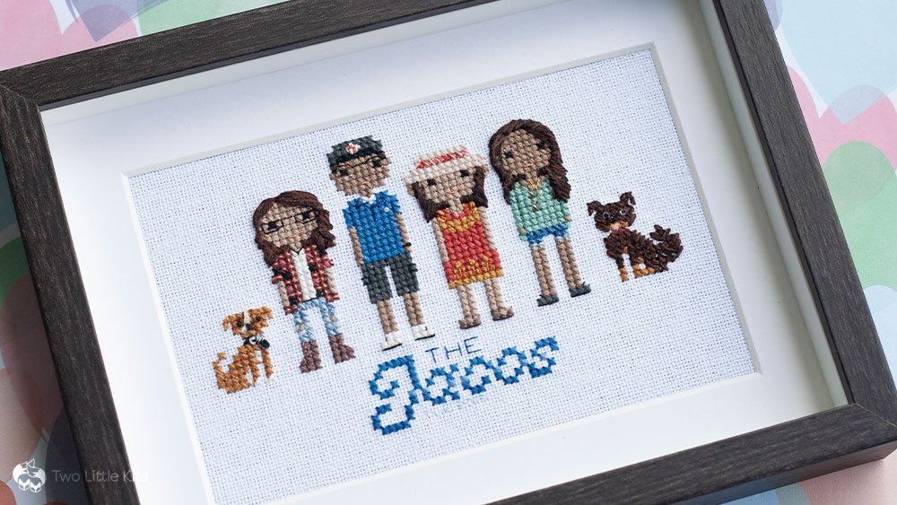 Cross-stitch finished piece: a family portrait of 4 people (Dad, Mum and 2 daughters) and their 2 dogs