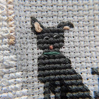 Funny black dog with cute ears cross-stitched