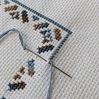 A cross-stitch that is being worked on using coloris floss