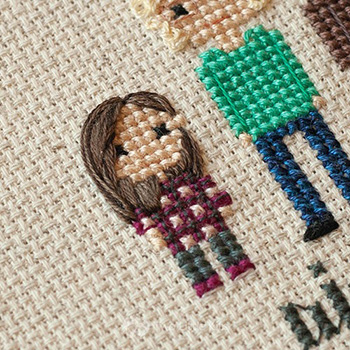 Cross-stitch & embroidery piece depicting a little girl with long, brown hair wearing a plaid shirt.