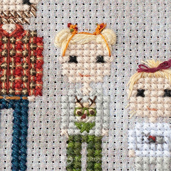 Cross-stitch & embroidery piece depicting a young girl in a reindeer shirt.