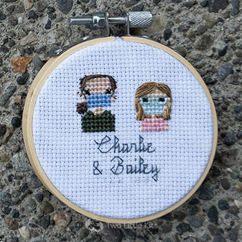 Bailey and Charlie, both cross-stitched wearing face masks in a stitch people style.