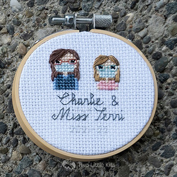Miss Terri and Charlie, both cross-stitched wearing face masks in a stitch people style.