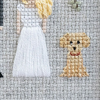 Close-up photo of the second dog and the dress of the bride. The dog is a puppy labrador so it's smaller than the other one and has the classic 'puppy-dog eyes'.