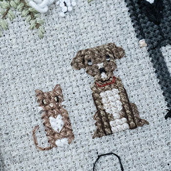 Close-up photo of one of the dogs and the cat. They are both done as cross-stitch characters. Both have very mottled colouring in their fur which is done combining 3 different colour flosses.