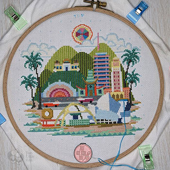 A photograph of a very colourful cross-stitch piece that is nearing completion. It is a depiction of key landmarks within Los Angeles.