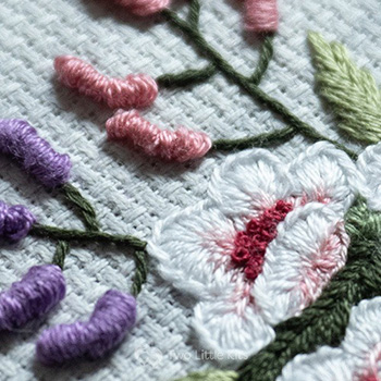 3D hand embroidered flowers. They're very intricately stitched and lots of detail can be seen.